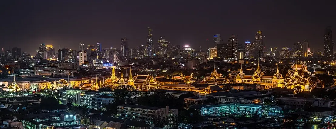 Der Grand Palace in Bangkok erstrahlt bei Nacht in einem magischen Licht und zieht Besucher mit seiner beeindruckenden Architektur und dem funkelnden Glanz der goldenen Dächer in seinen Bann. 